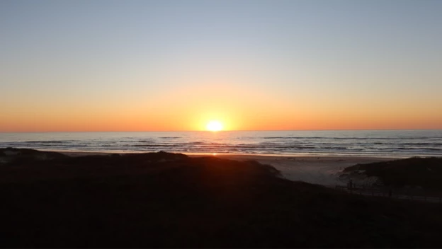 Sunrise An orange sunrise covering the horizon over the ocean.