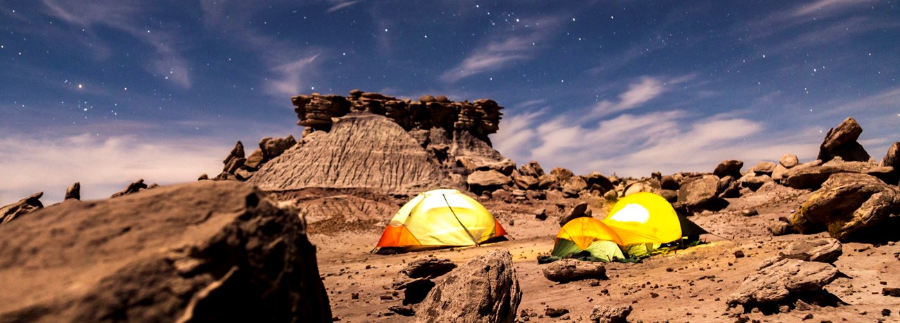 PEFO Camping Devils Playground NPS Jacob Holgerson Several tents in a rocky desert under the stars at night