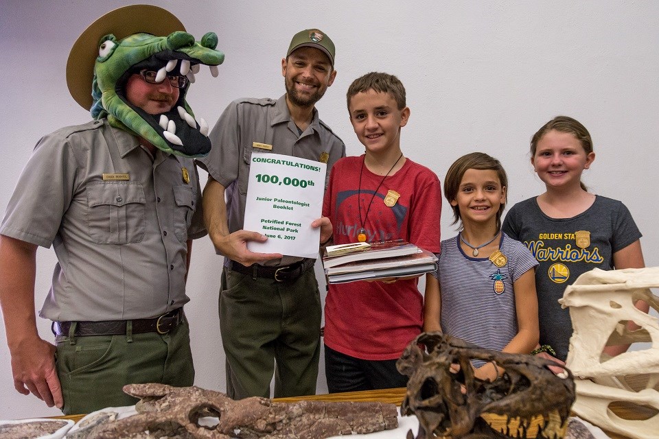 Rangers with Junior Rangers standing near fossils