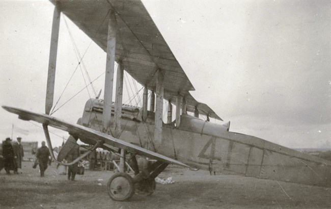 Black and white photograph showing a DH-4 aircraft with the number "4" painted on its side.