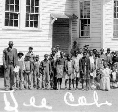 Children in front of a schoolhouse.