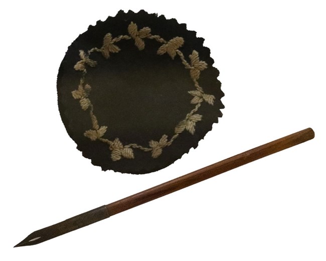 Pen and fabric pen wiper A black and brown ink dip pen, with a round piece of fabric used to wipe excess ink