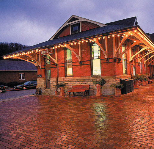 Pennsylvania Railroad Depot Brick building with string lights near a brick sidewalk.