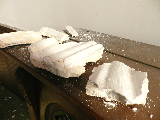Pieces of plaster molding. Five big pieces of white plaster chunks on a table.