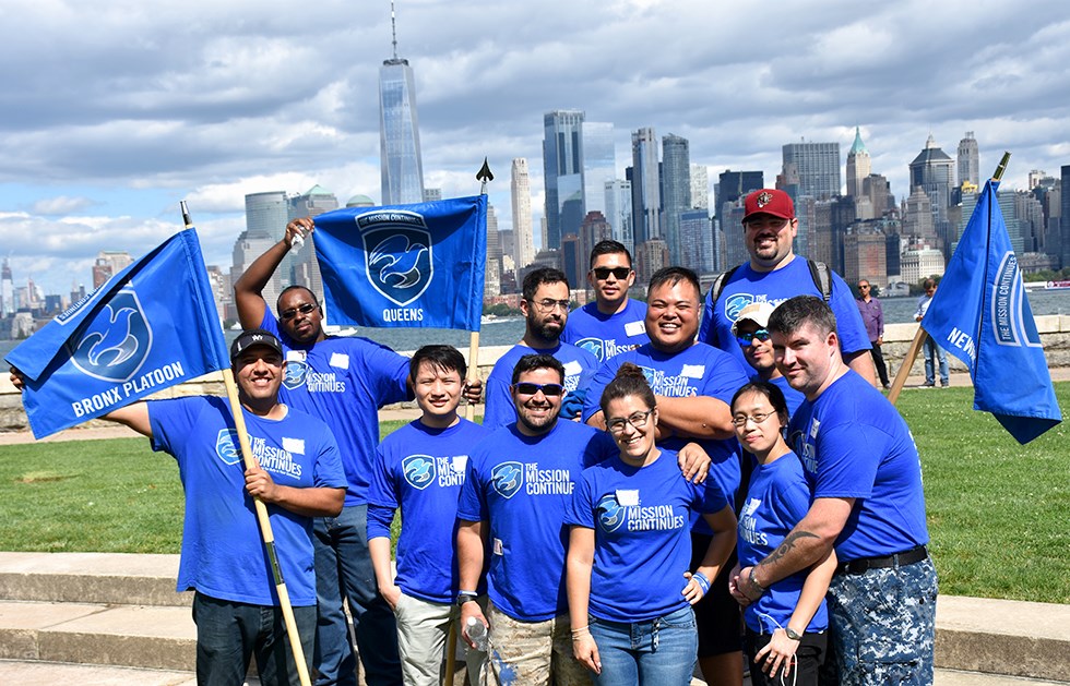 The Mission Continues on Ellis Island group of people wearing blue mission continues t-shirts manhattan in background