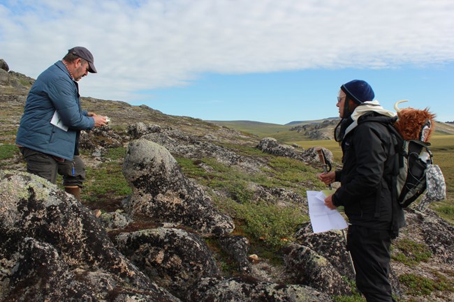 two people standing on a mountainside