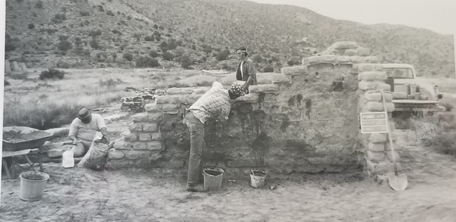 Stabilization efforts on the old hospital, 1973. Three men complete stabilization efforts on the old hospital wall, 1973.