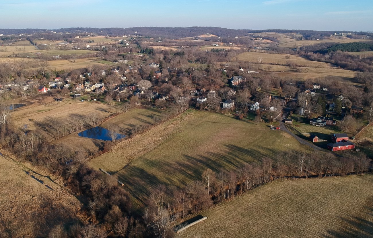 Color aerial photo of the open space and agricultural land that are included in the Waterford Historic District. Open fields and trees in the foreground surround the houses in the historic village.