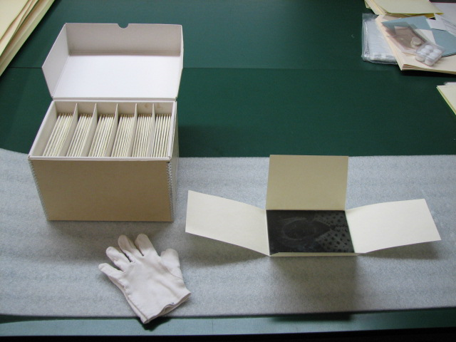 A white box and white cotton gloves on a desk.