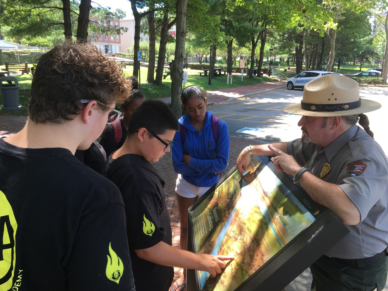 Ranger talks to teens at wayside interpretive sign