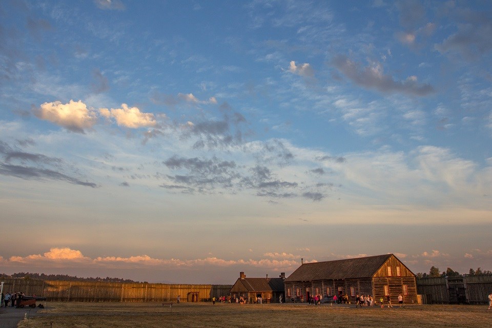 Photo of the interior of Fort Vancouver with visitors around buildings.