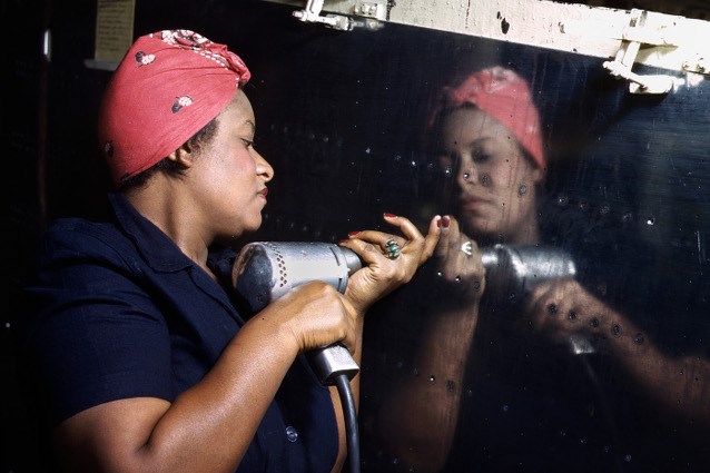 A woman works on an A-31 Vengeance dive bomber at Vultee-Nashville, Tennessee in 1943. An African American "Rosie" installing rivets on a war plane.