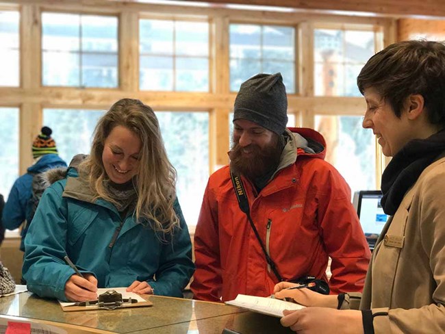 People at the visitor center counter talking.