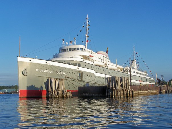 Large grey, white, and red boat in the water.