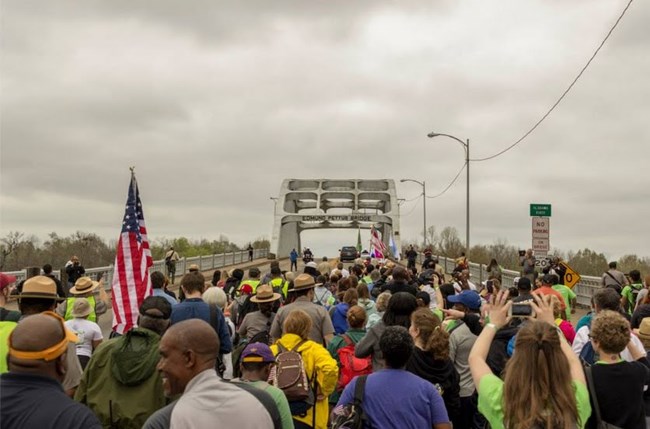 People waiting to cross the Edmund Pettus Bridge A large group of people waiting to cross the Edmund Pettus Bridge