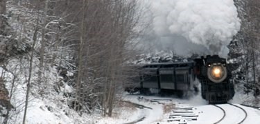 Steam engine moving through a winter landscape