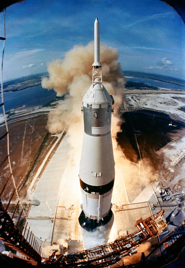 Saturn V Apollo 11 launch Top of Saturn V rocket during launch; flames from thrusters can be seen behind rocket