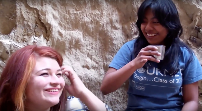 Friends take a water break while hiking in the wilderness.