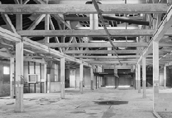 B&W photo of heavy timber ceiling framing in the stables.