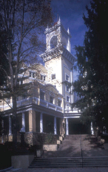 Tall white tower connected to a building.