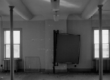 Fort Des Moines, barracks building 56 B&W image of two columns, two windows, and two rounded plaster ceiling features on the interior of a building.