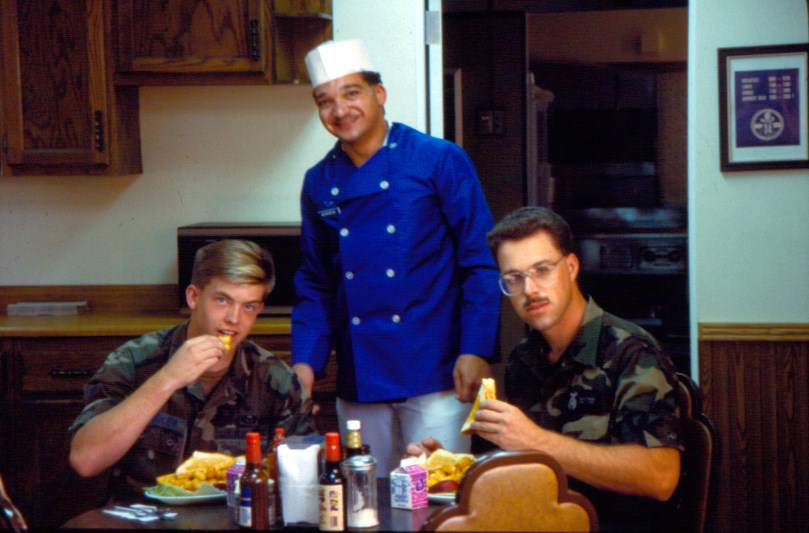 Security Police enjoying a meal prepared by a Missile Rations Cook A military chef with two uniformed airmen