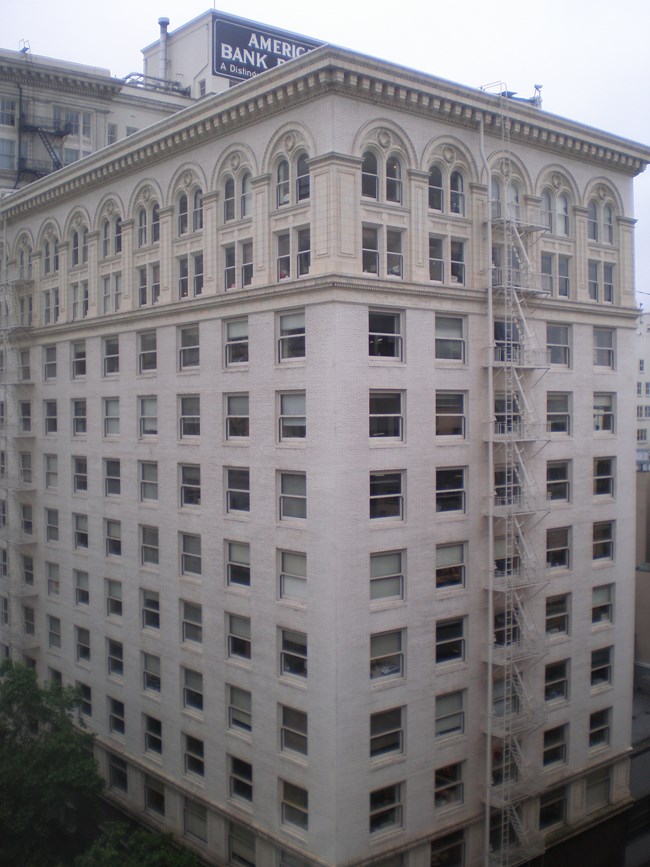 Exterior of a multi-story building. A fire escape runs up the side.