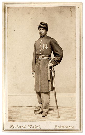 African American man in Civil War Union Army uniform with medals on his chest leaning on a sword
