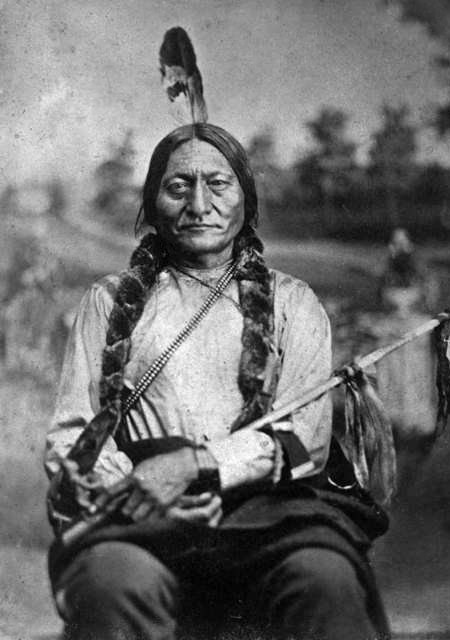 Black and white photo of Sitting Bull holding his pipe