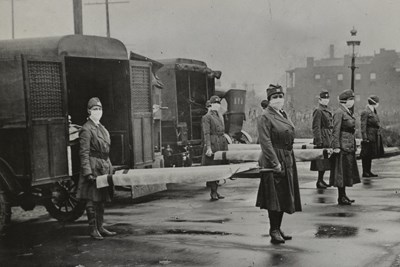 Female ambulance operators holding stretchers with masks on