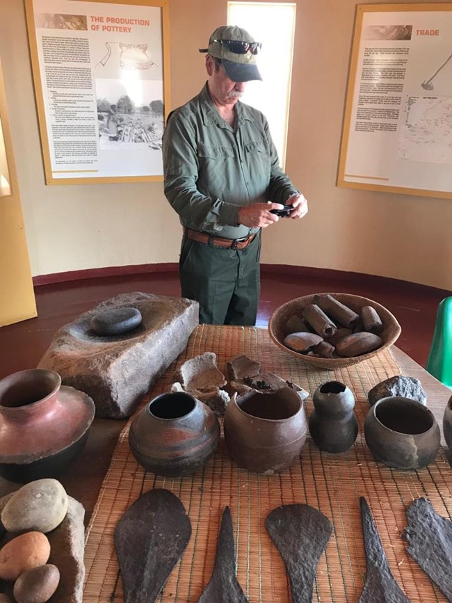Stan Bond examining iron artifacts in a museum collection