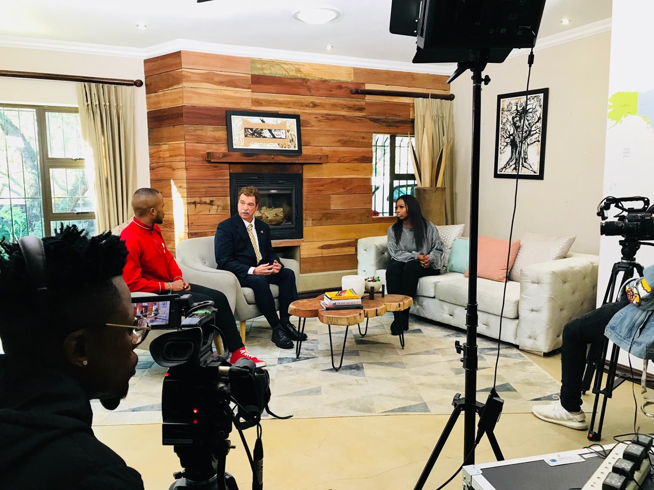 Stan Bond being filmed and interviewed by two hosts on a TV set