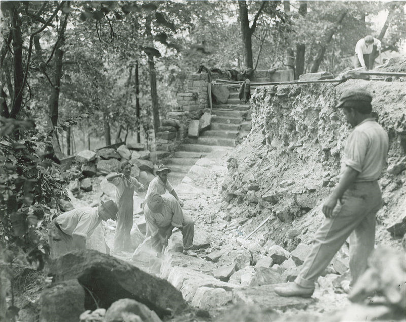 B&W photo of construction workers building a wall.