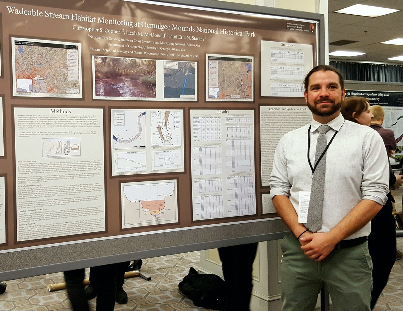 SECN graduate assistant Stephen Cooper stands in front of poster SECN graduate assistant Stephen Cooper stands in front of poster