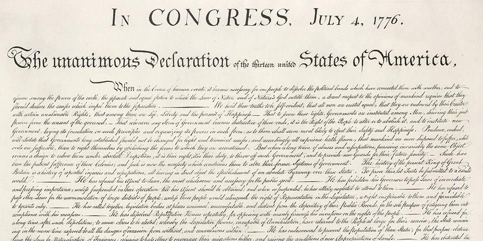 Color image of the handwritten Declaration of Independence with black text on cream paper.