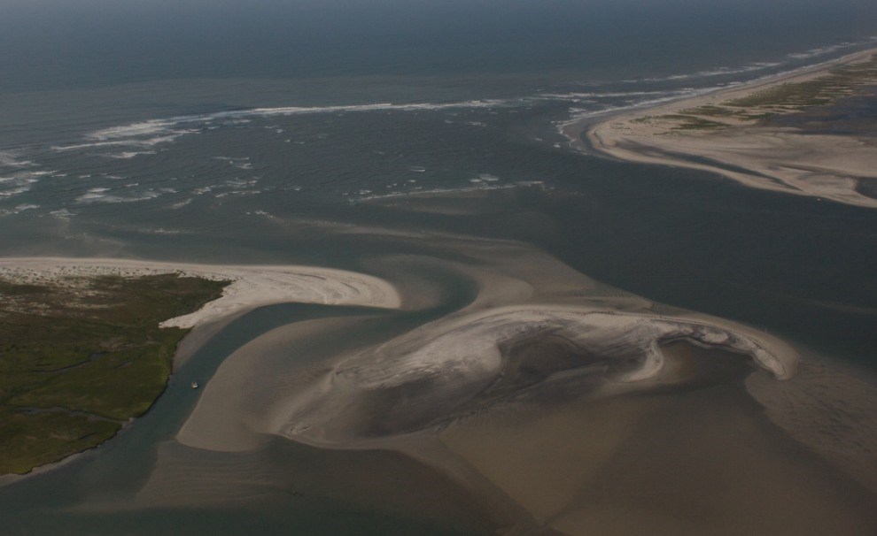 water flowing through inlet in barrier island