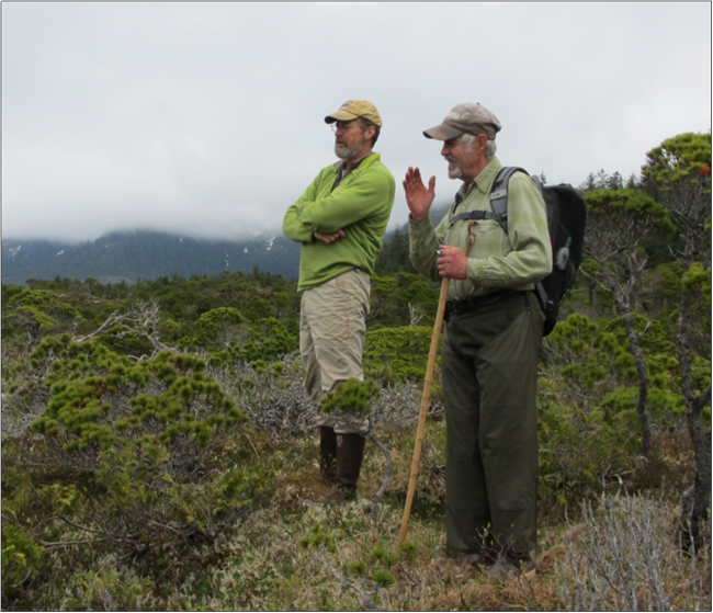 two people stand in a field talking