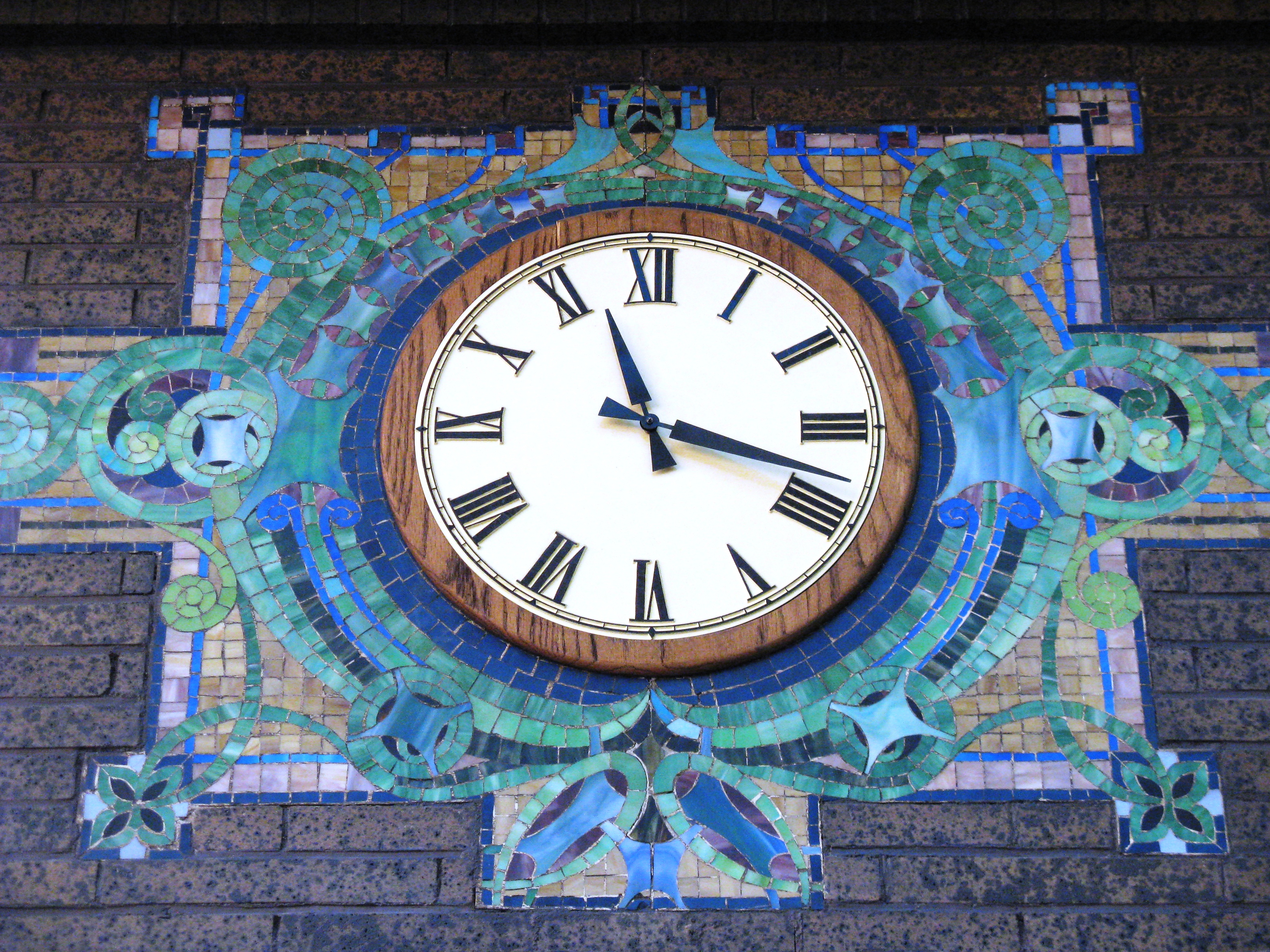 Clock with a colorful mosaic around it.