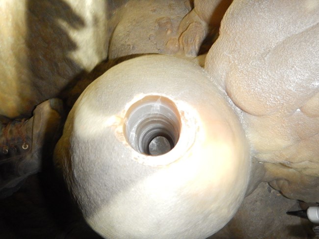 cave formation with hole drilled in it