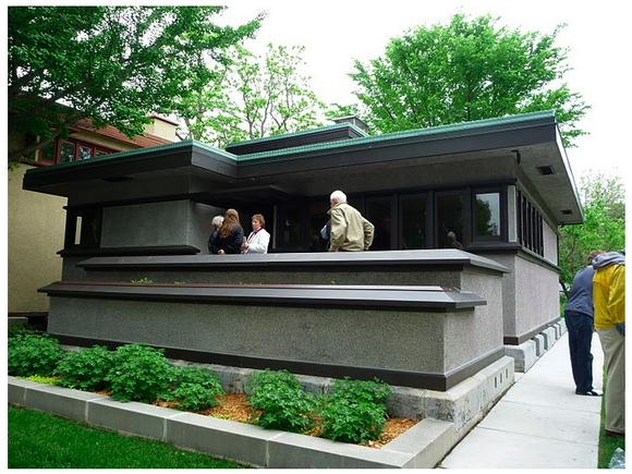 Grey house with people on the front porch.