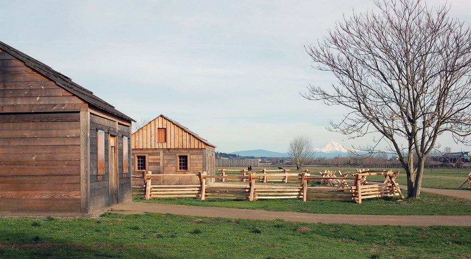 Photo of two small wooden cabins with Mount Hood in the background.