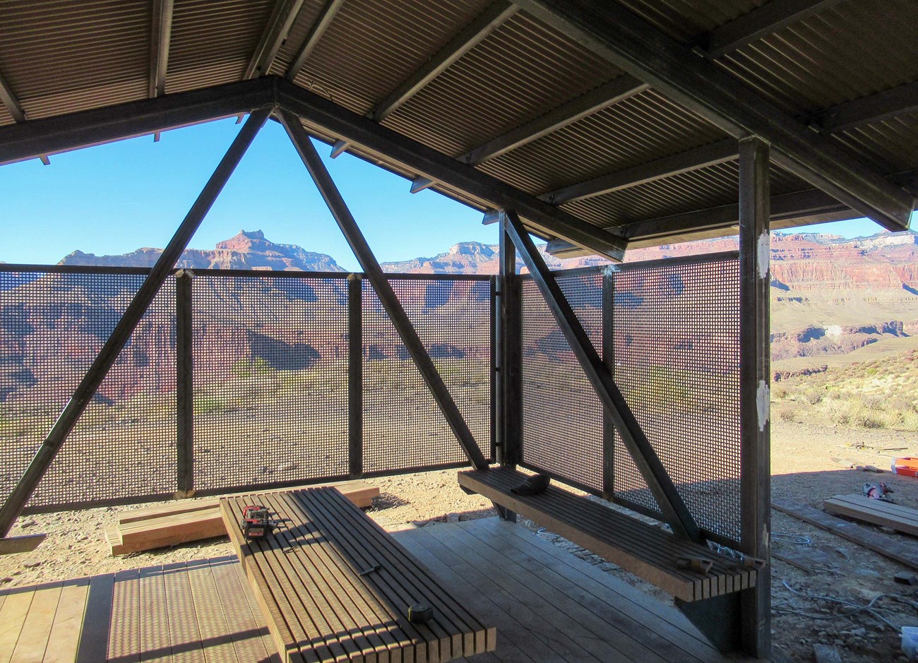 interior of open-air shade structure showing position of benches, and side-wall shade screens