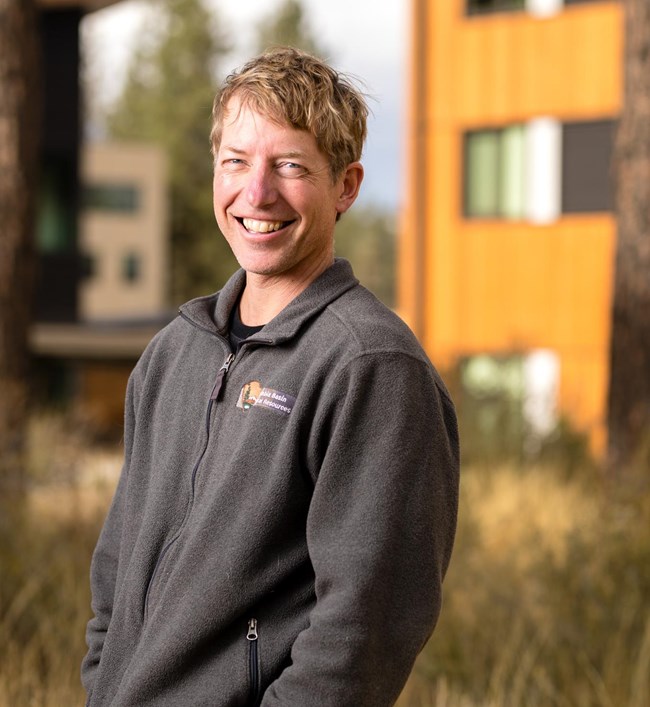 Portrait of biologist Tom Rodhouse smiling brightly.