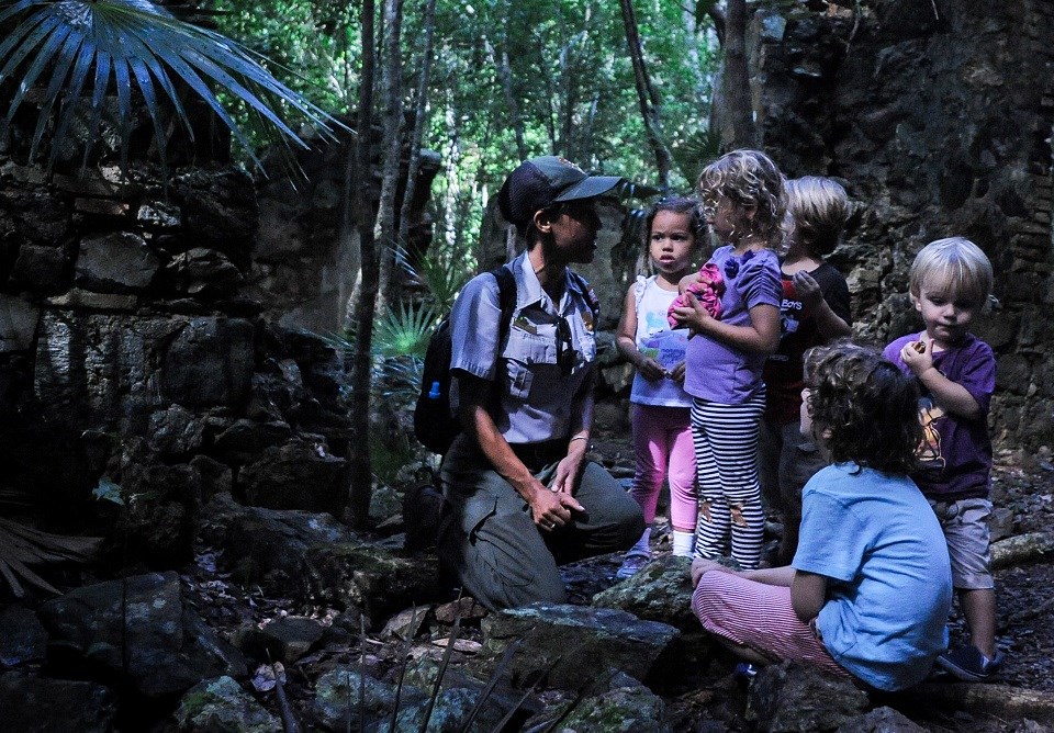 VIIS Junior Ranger Program Ranger with a group of kids in a tropical forest