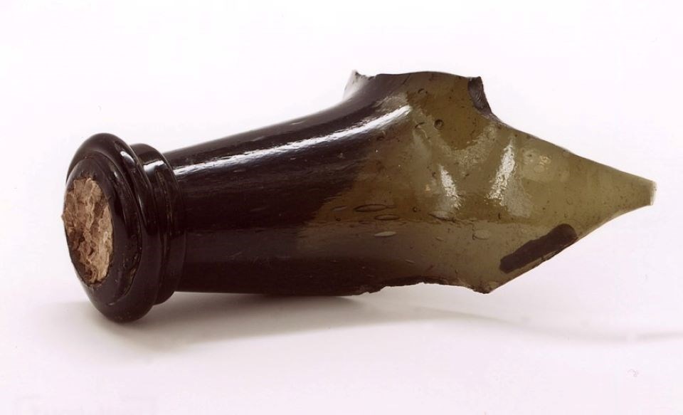 lt= broken neck of a green glass wine bottle with cork
