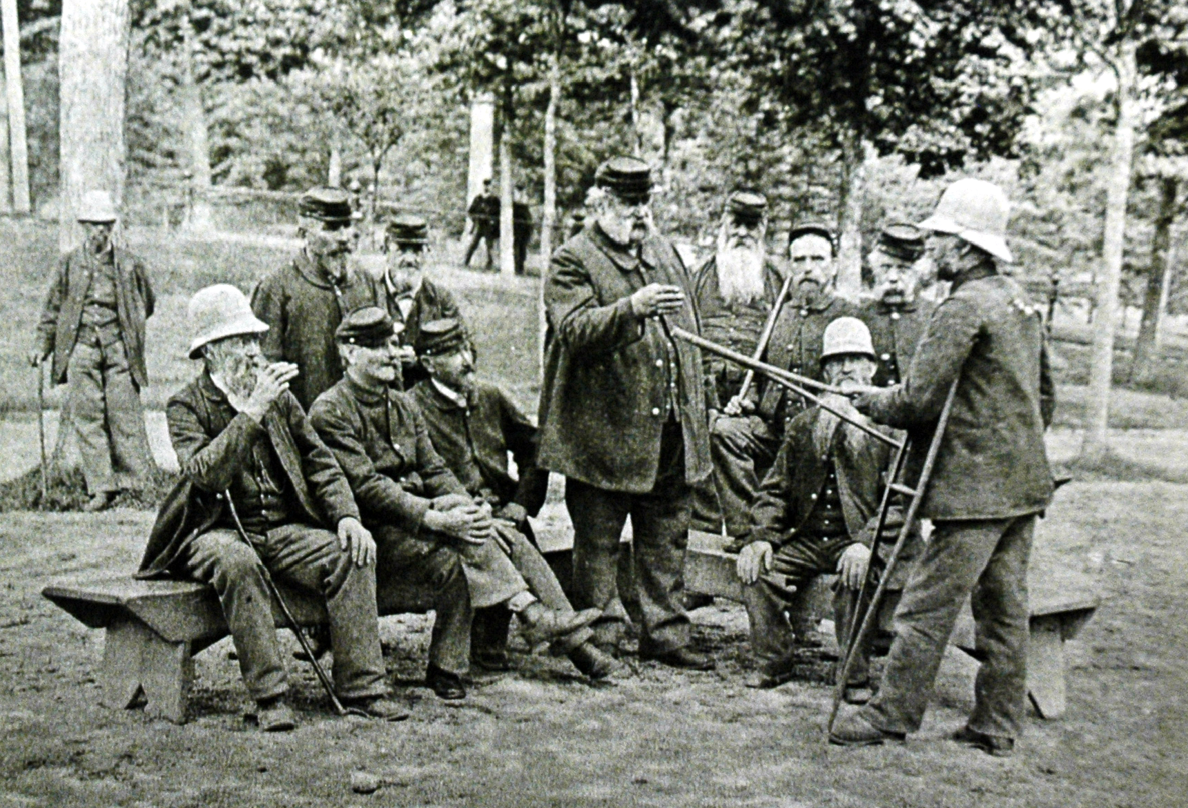 B&W photo of men standing and sitting in a group.