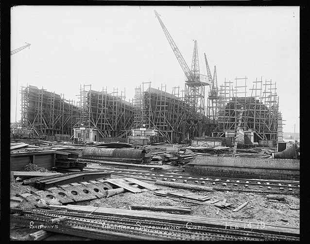 Ships surrounded by scaffolding being built in a shipyard
