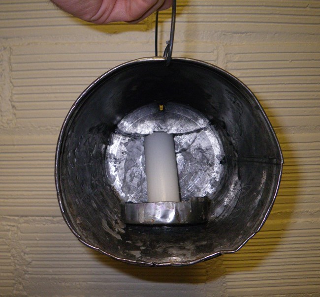 wax candle in metal reflector bucket