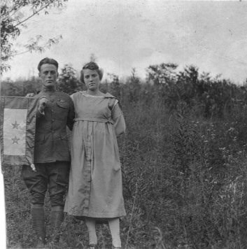 black and white photo depicts sister and brother holding banner with two stars