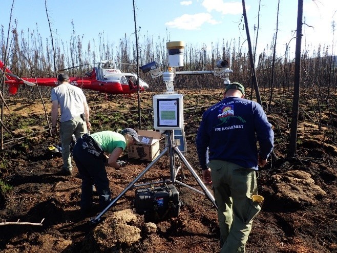 Ecologists set up a weather station on a sunny day.